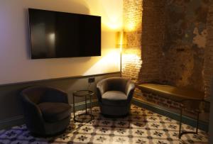 una sala d'attesa con 2 sedie e una TV a schermo piatto di Royal Tophane a Istanbul