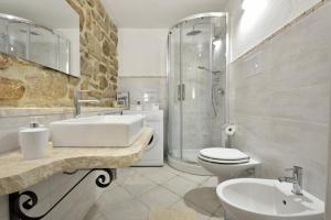 a bathroom with a sink and a toilet and a shower at GRECALE a pochi passi dal mare in Santa Maria Navarrese +22 photos