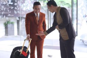 a man in a suit shaking another mans hand at Midtown Hotel Surabaya in Surabaya