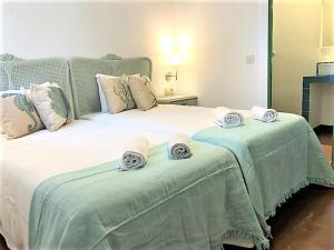 a bedroom with a large bed with towels on it at Villas en Toledo in Villaluenga