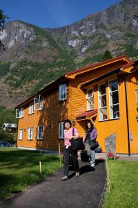 a woman sitting on a bench in front of a building at Flåm Hostel in Flåm