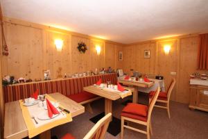 ウムハウゼンにあるHaus Rosiの木製の壁とテーブルと椅子が備わるレストラン