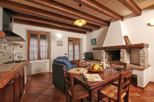 a kitchen and living room with a wooden table and a dining room at Agriturismo Al Lambic in Tignale
