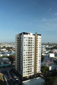 a tall white apartment building in a city at Deluxe apartment with balcony, pool, fitness and yoga in Ho Chi Minh City