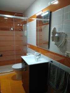 y baño con lavabo, aseo y espejo. en Casa la Isabelica, en Belmonte