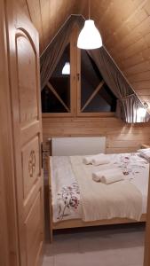 a bedroom with a bed in a wooden cabin at Domek Góralski na Gubałówce in Zakopane