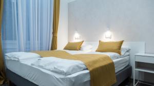 2 Betten in einem Hotelzimmer neben einem Fenster in der Unterkunft BpR Downtown Gemstone Apartments in Budapest
