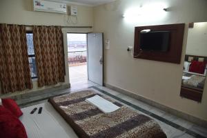 a room with a bed and a flat screen tv at Hotel Ganga Basin in Haridwār