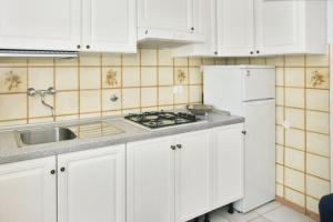 eine Küche mit weißen Schränken, einer Spüle und einem Kühlschrank in der Unterkunft Il Podesta in Florenz