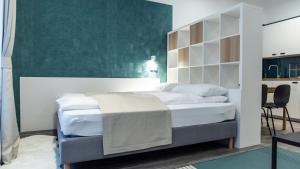ein Schlafzimmer mit einem Bett und einer grünen Wand in der Unterkunft BpR Downtown Gemstone Apartments in Budapest