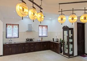 eine Küche mit Holzschränken und einigen Lampen in der Unterkunft Villa Calangute Phase 10 in Calangute