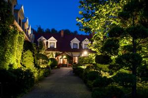 una casa por la noche con luces en un camino en Hubertus Aparthotel & Restaurant & Horse Club, en Starogard Gdański