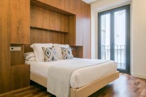 a bedroom with a large bed with a wooden headboard at Hommyhome Arenal Luxury in Seville