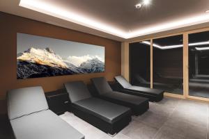 a living room with a couch and a picture of mountains at Residenz Gramaser GmbH in Ischgl