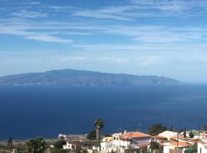 a view of the ocean with houses and a palm tree at Casa Victoria in Adeje