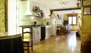 Casa Jacobea في Grañón: مطبخ مع دواليب بيضاء وغرفة طعام