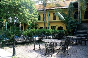 a patio with tables and chairs in front of a building at Hotel Oaxtepec in Oaxtepec