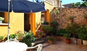 a patio with a table and an umbrella and potted plants at Casa Jacobea in Grañón