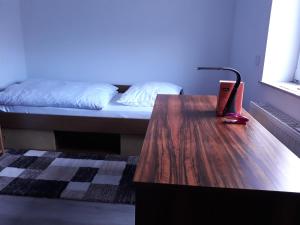 Ein Zimmer mit einem Bett und einem Holztisch mit einem Schreibtisch sidx sidx. in der Unterkunft Hanover Fair Rooms in Hannover