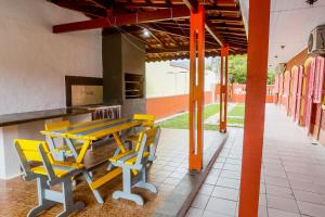 a table and chairs in a building with orange poles at Pousada Gaivotas de Maranduba in Ubatuba