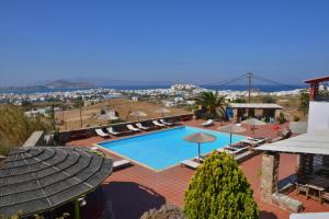 a swimming pool with chairs and umbrellas on a resort at Paradisia Villas in Naxos Chora