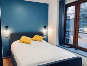 Un pat sau paturi într-o cameră la Le Madame Little Appart’Hotel