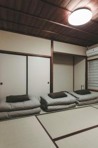 Postel nebo postele na pokoji v ubytování Yonemuraya, the well-restored Japanese Showa Style House 米村家