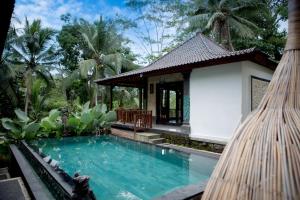 a villa with a swimming pool and a building at Ayu Duwur Beji in Ubud