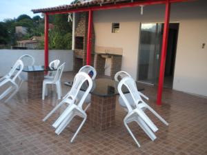 Cobertura paraiso Cacoes في Jaguaripe: مجموعة من الكراسي البيضاء وطاولة على الفناء