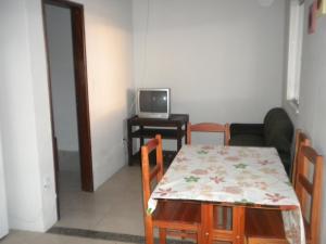 a dining room with a table and a tv at Cobertura paraiso Cacoes in Jaguaripe