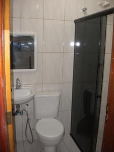 a bathroom with a toilet and a sink and a shower at Cobertura paraiso Cacoes in Jaguaripe