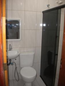 y baño con aseo, lavabo y ducha. en Cobertura paraiso Cacoes, en Jaguaripe