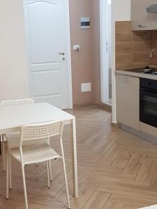 a kitchen with a white table and chairs in a room at Antichi Soffitti in Catania