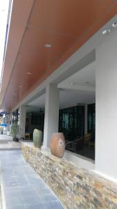 a building with two vases sitting on a ledge at Abani Inn in Jomtien Beach