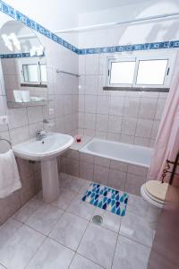 bagno con lavandino, vasca e servizi igienici di Calheta Holiday Houses ad Arco da Calheta