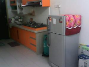 a small kitchen with a refrigerator and a stove at GERIK BANDING HOMESTAY in Gerik