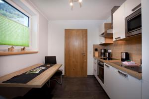 een kleine keuken met een houten tafel en een aanrecht bij Apart Bergzeit in Nauders +27 foto's