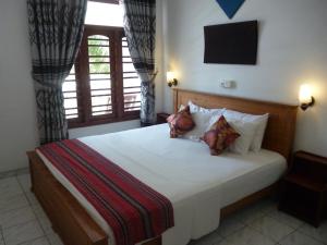 a bedroom with a large bed with pillows and a window at Hotel Ocean View Cottage in Hikkaduwa +62 photos