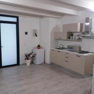 a kitchen with a stove and a refrigerator in a room at La Corte di Aci in Acireale