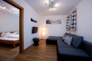 een woonkamer met een bank en een bed bij Apart Bergzeit in Nauders