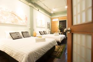 a room with two beds and a door with a door at The Orientale Hostel in Bangkok
