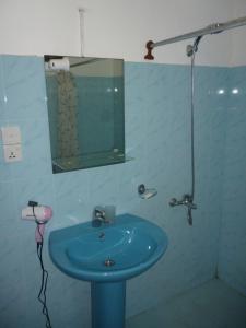 a bathroom with a blue sink and a mirror at Hotel Ocean View Cottage in Hikkaduwa