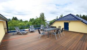 un patio con mesa y sillas en una terraza en Strandhaus Eden en Senftenberg