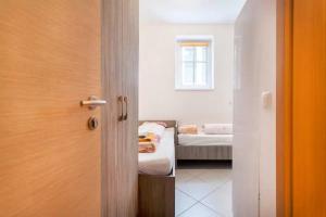 Una puerta que conduce a una habitación con 2 camas en Apartments FABRKA, en Liubliana
