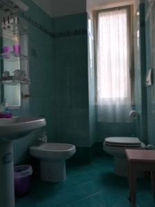 ローマにあるIl Vostro Comfortの緑豊かなバスルーム(トイレ、シンク付)