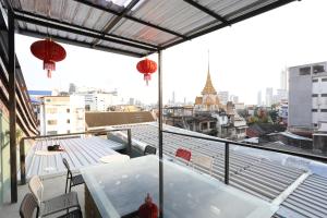 a balcony with a table and a view of a city at The Orientale Hostel in Bangkok