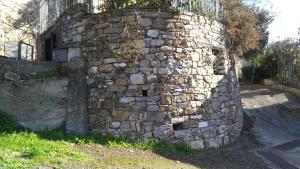 uma velha parede de pedra ao lado de um edifício em Alloggio Basilico em Diano San Pietro