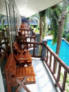 a row of lounge chairs on a balcony with a pool at Aonang Village Resort in Ao Nang Beach