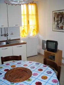 a kitchen with a table with a table cloth on it at Alloggio Basilico in Diano San Pietro