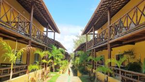 a courtyard of a building with palm trees in it at Linda Casa de Praia em Itacimirim in Itacimirim